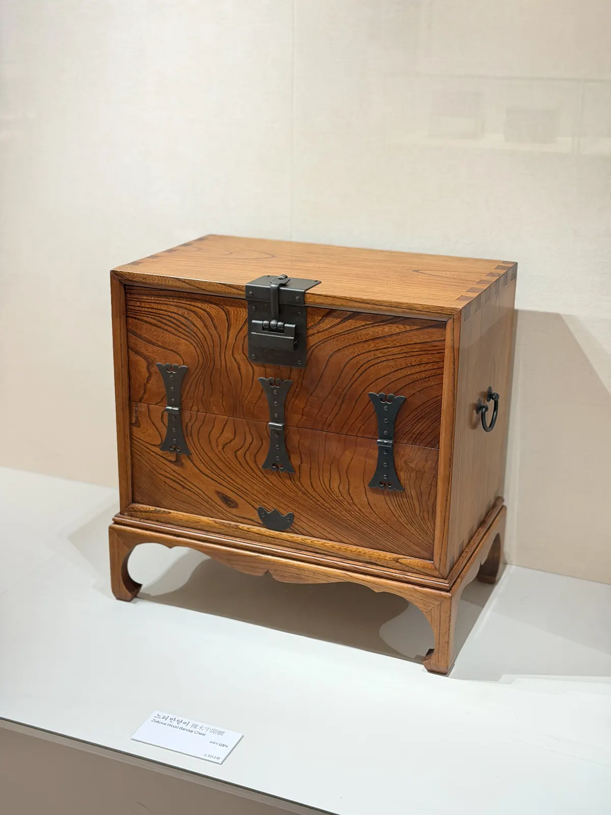A wooden chest on short legs with iron fittings